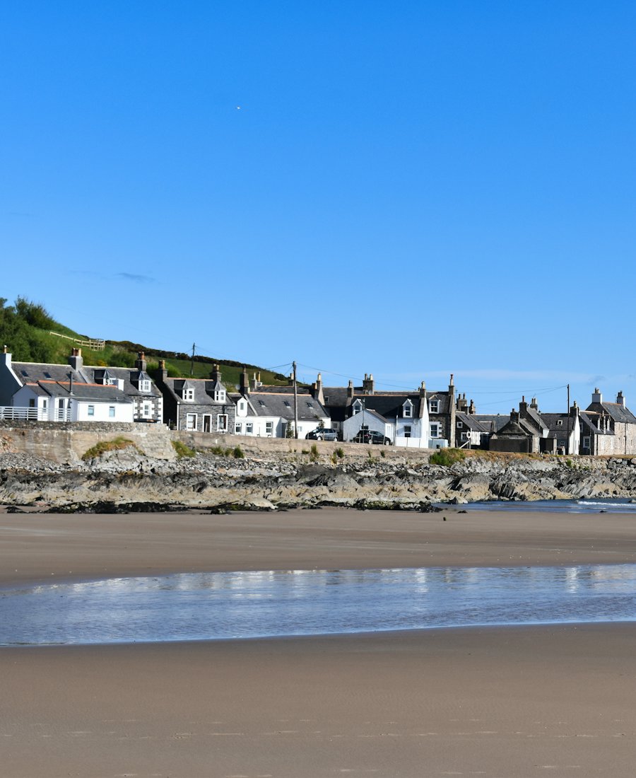 Wide sandy beach with houses on the horizon