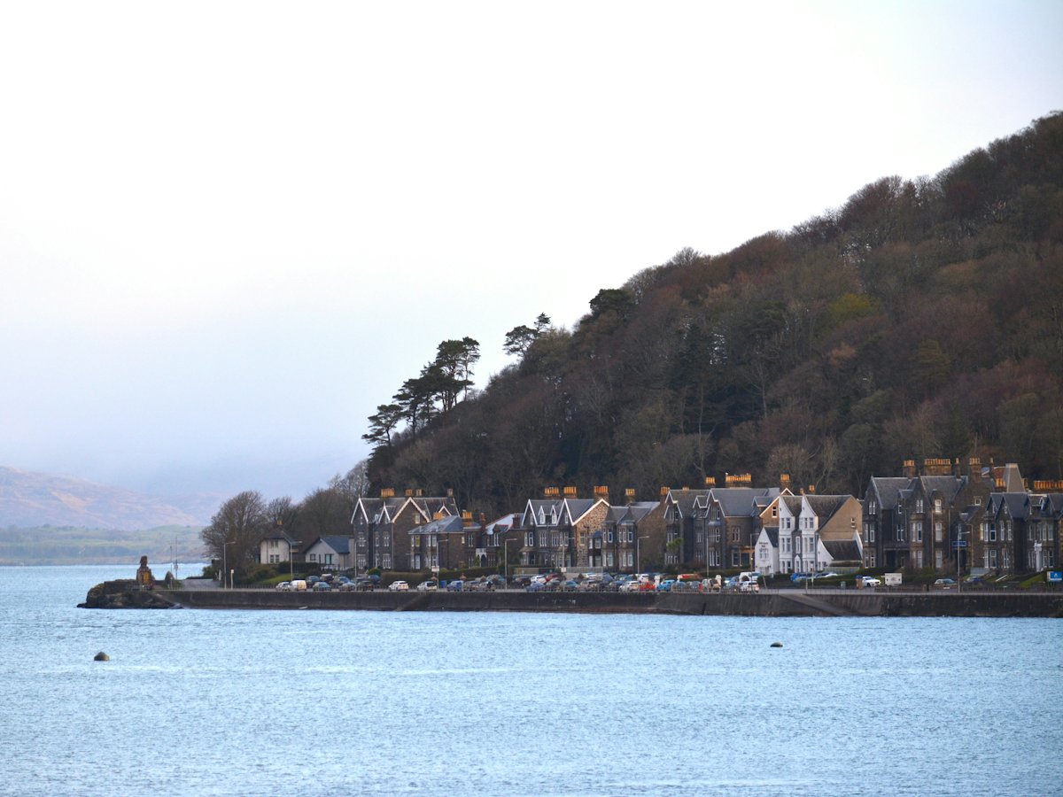 Victorian villas along a wooded shoreline above calm water