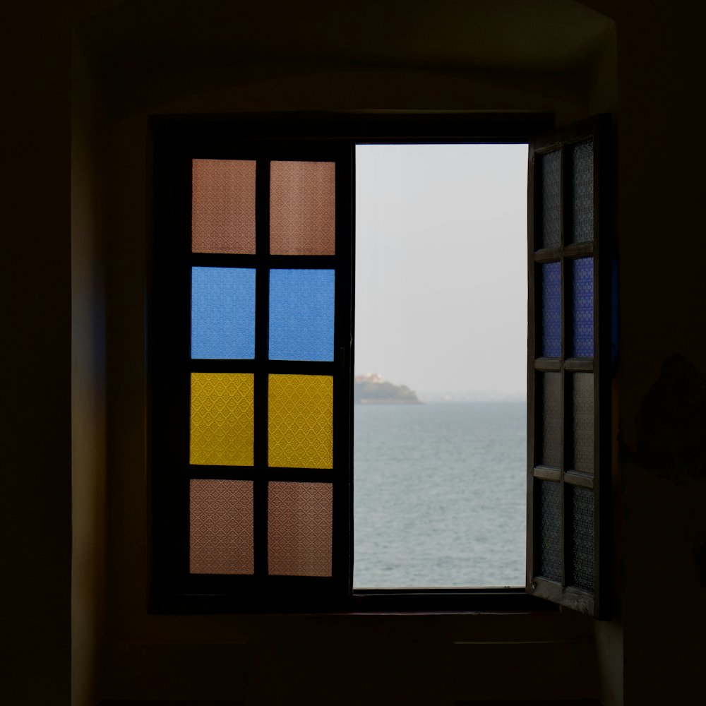 Sea view framed by a window with coloured glass panes